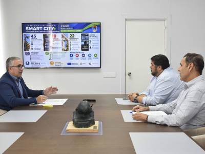 Reunión en el Ayuntamiento de Los Palacios y Villafranca sobre el proyecto Smart City, con la infografía del plan en la pantalla